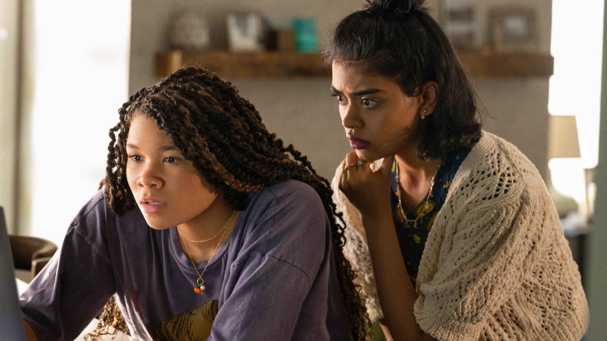 Storm Reid and Megan Suri look worried reading a computer screen in the film "Missing."