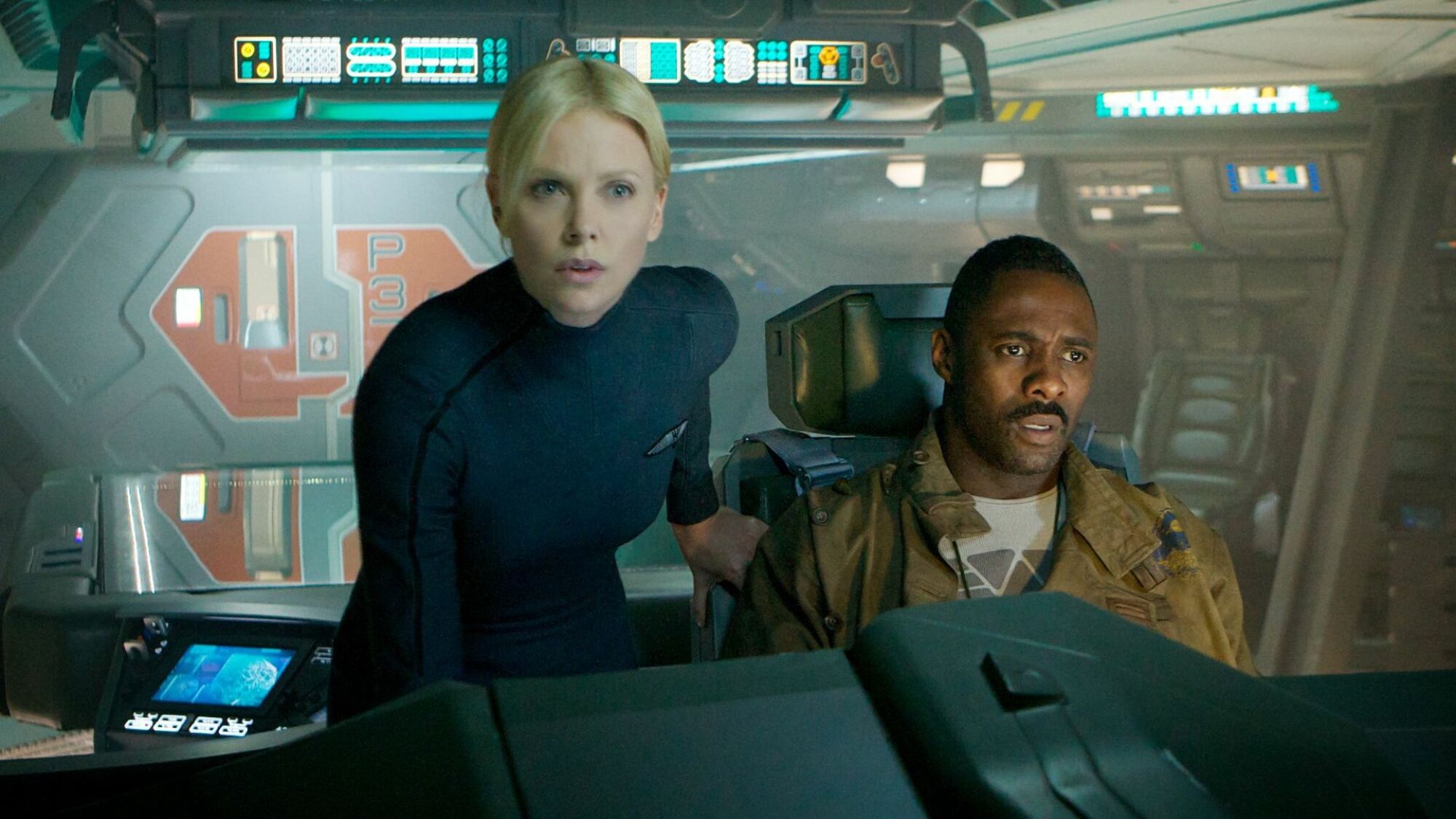 Charlize Theron and Idris Elba look stern in a spaceship. 