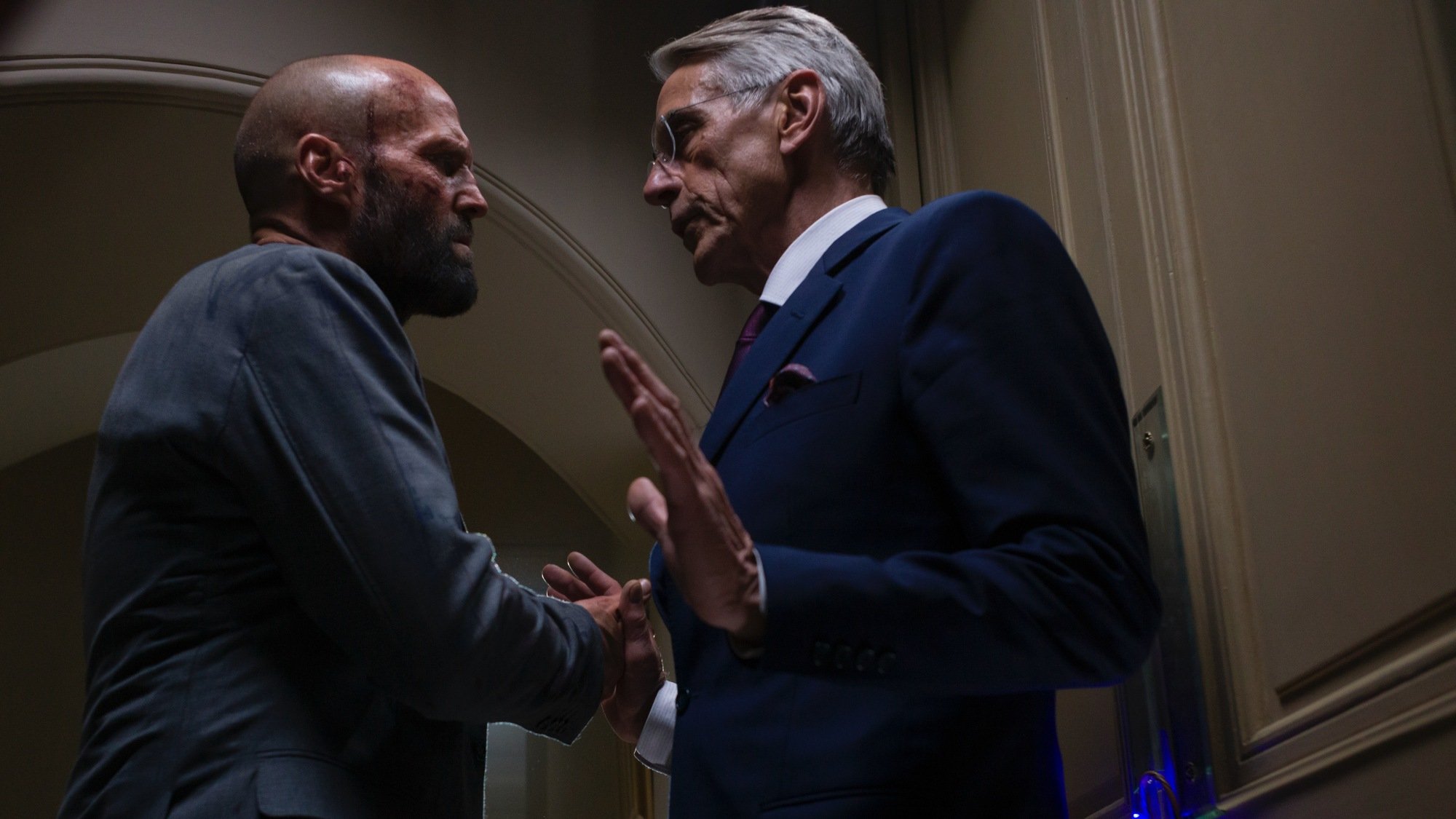 Jason Statham accosts Jeremy Irons. 