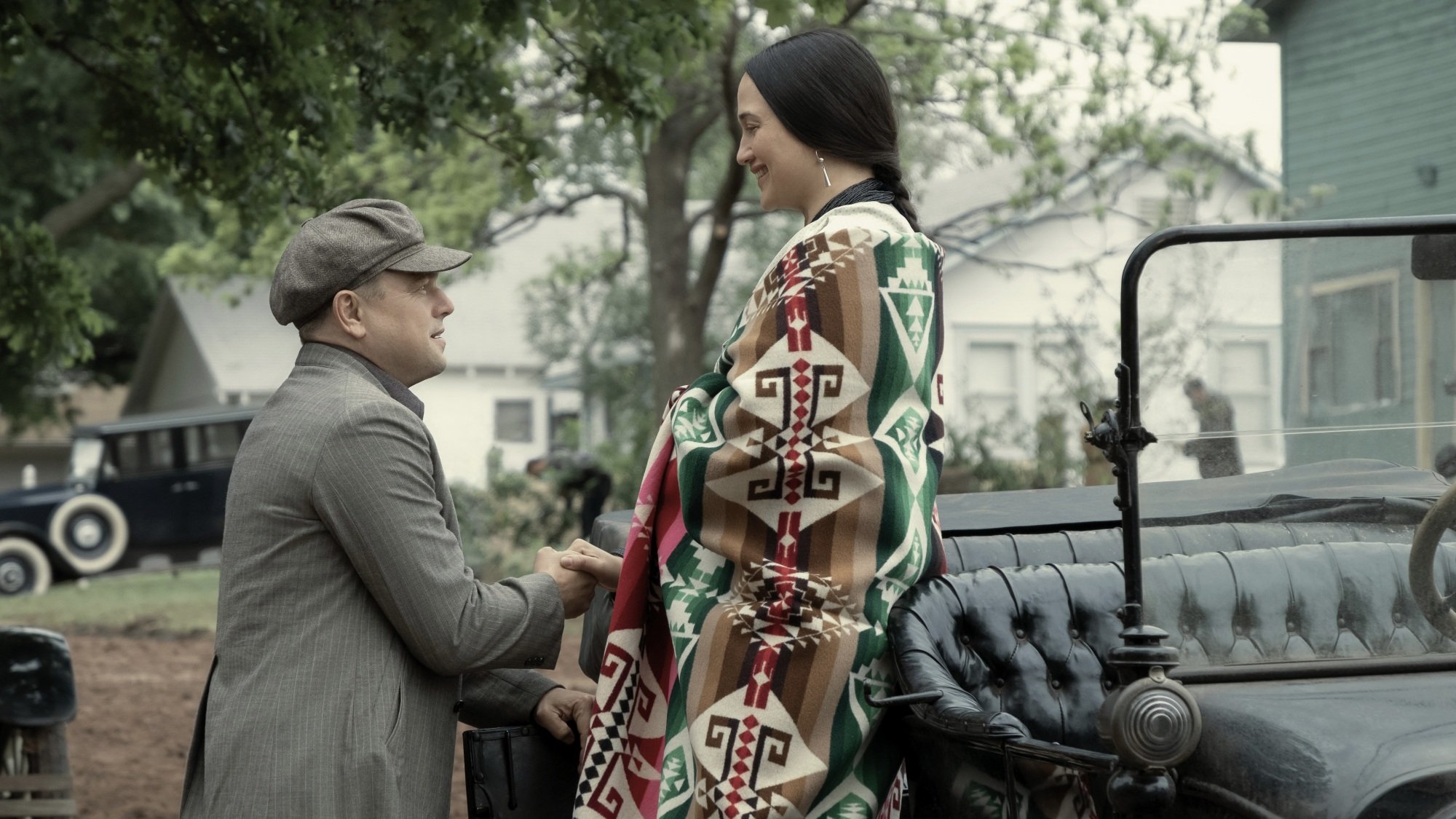 A man helps a woman out of a car.