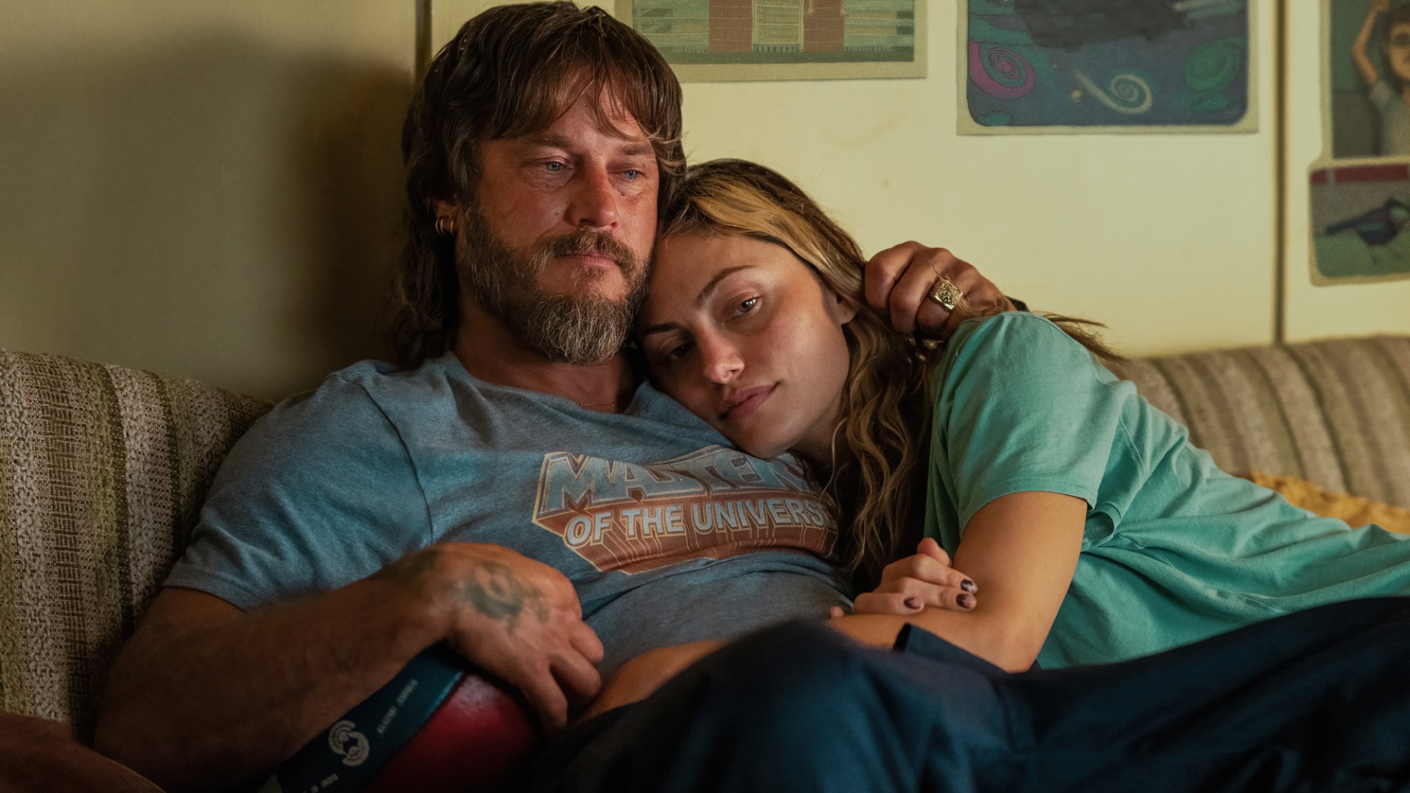 A couple hug on the couch.