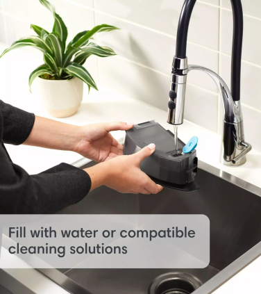 Person filling Roomba water tank in sink