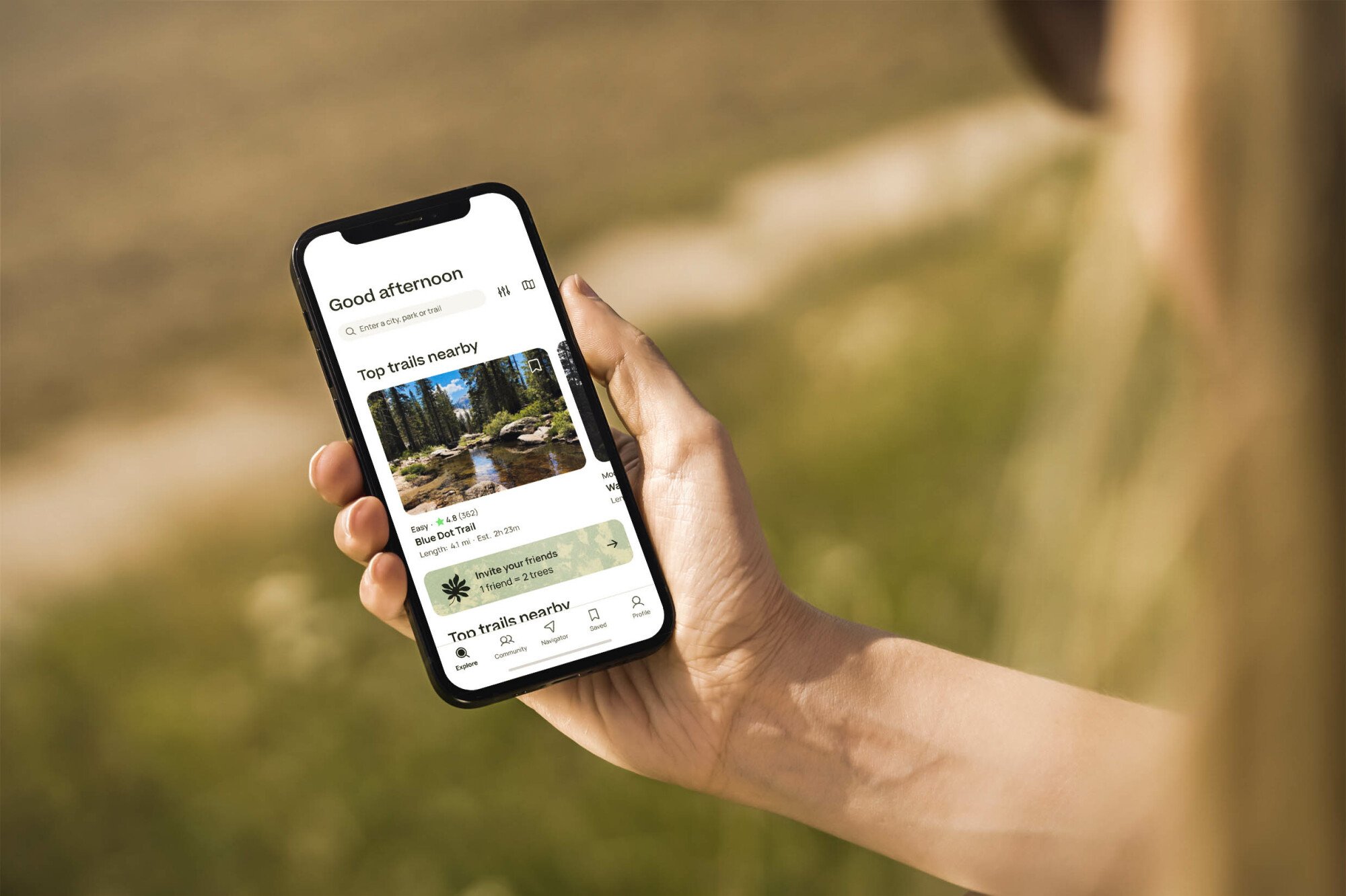 Person holding a smartphone with the AllTrails app pulled up on the screen