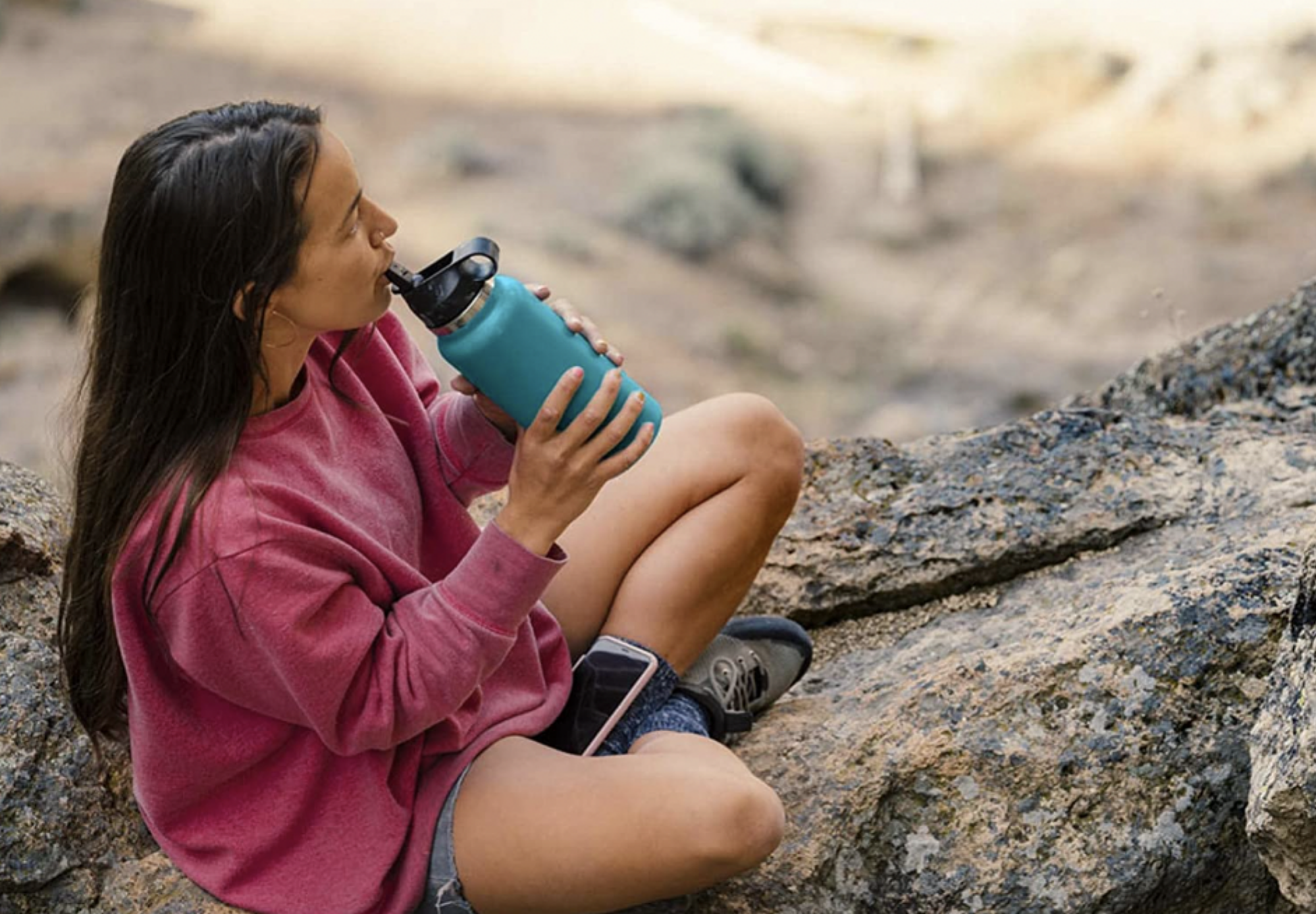 woman sipping from Hydroflask water bottle