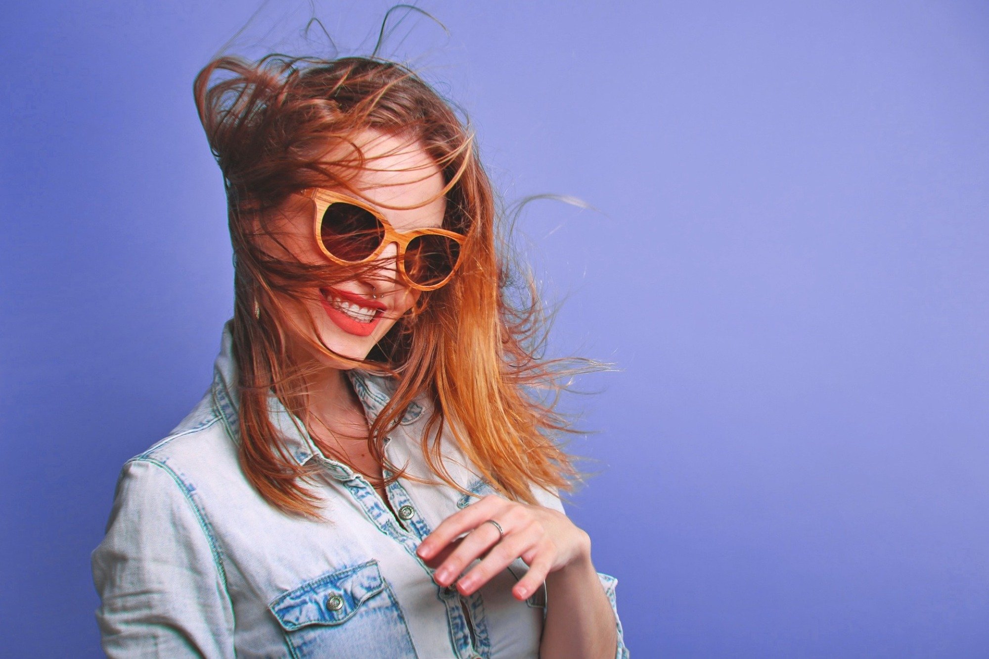 woman wearing sunglasses in front of blue background