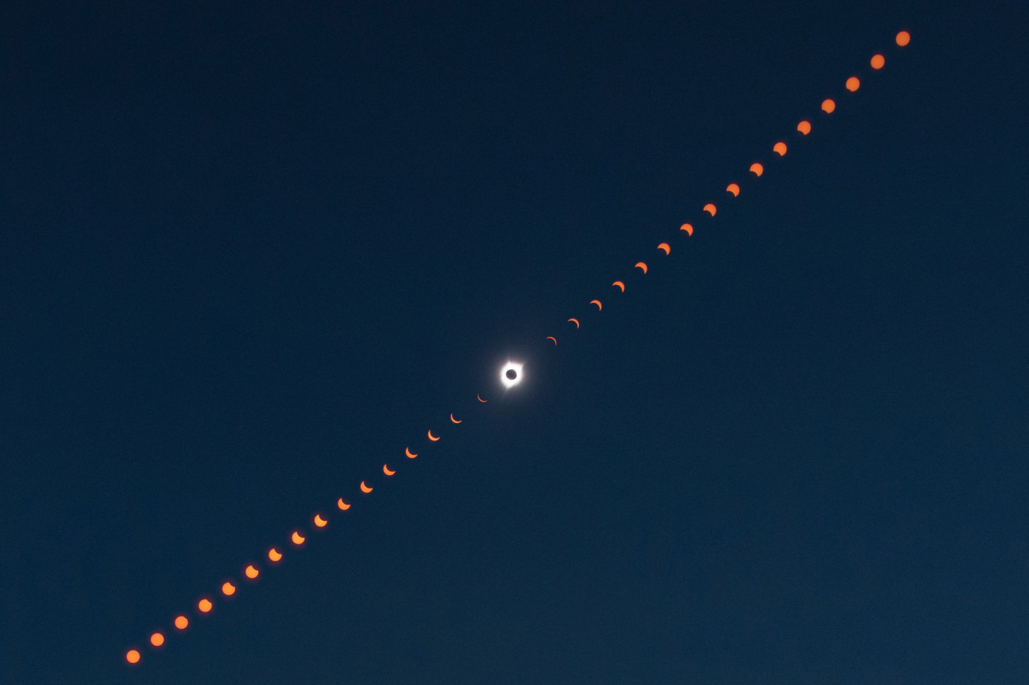 A composite image showing the progression of the total solar eclipse from partial to totality, and again to partial.