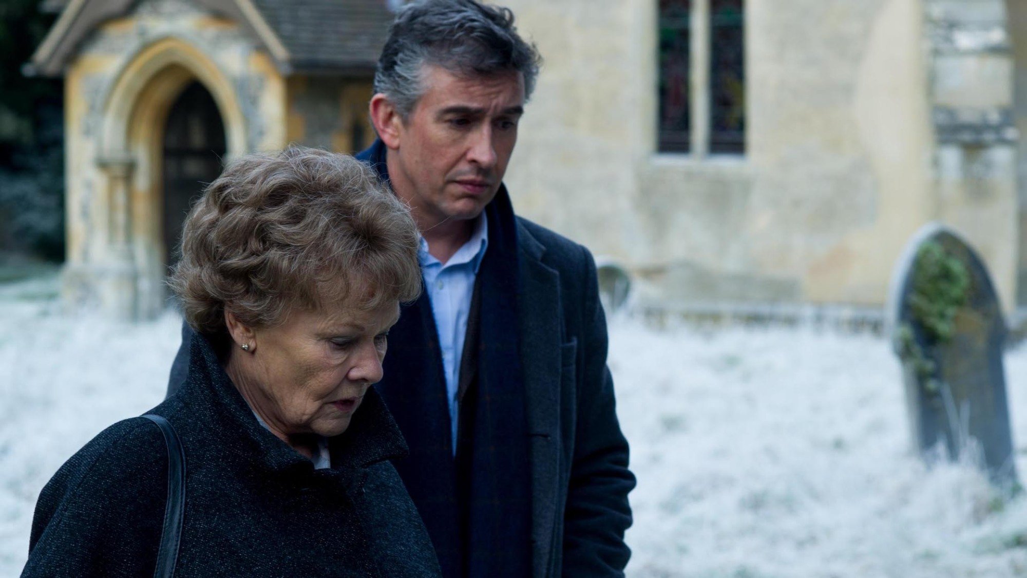 Judi Dench and Steve Coogan walk near a church in the film "Philomena"