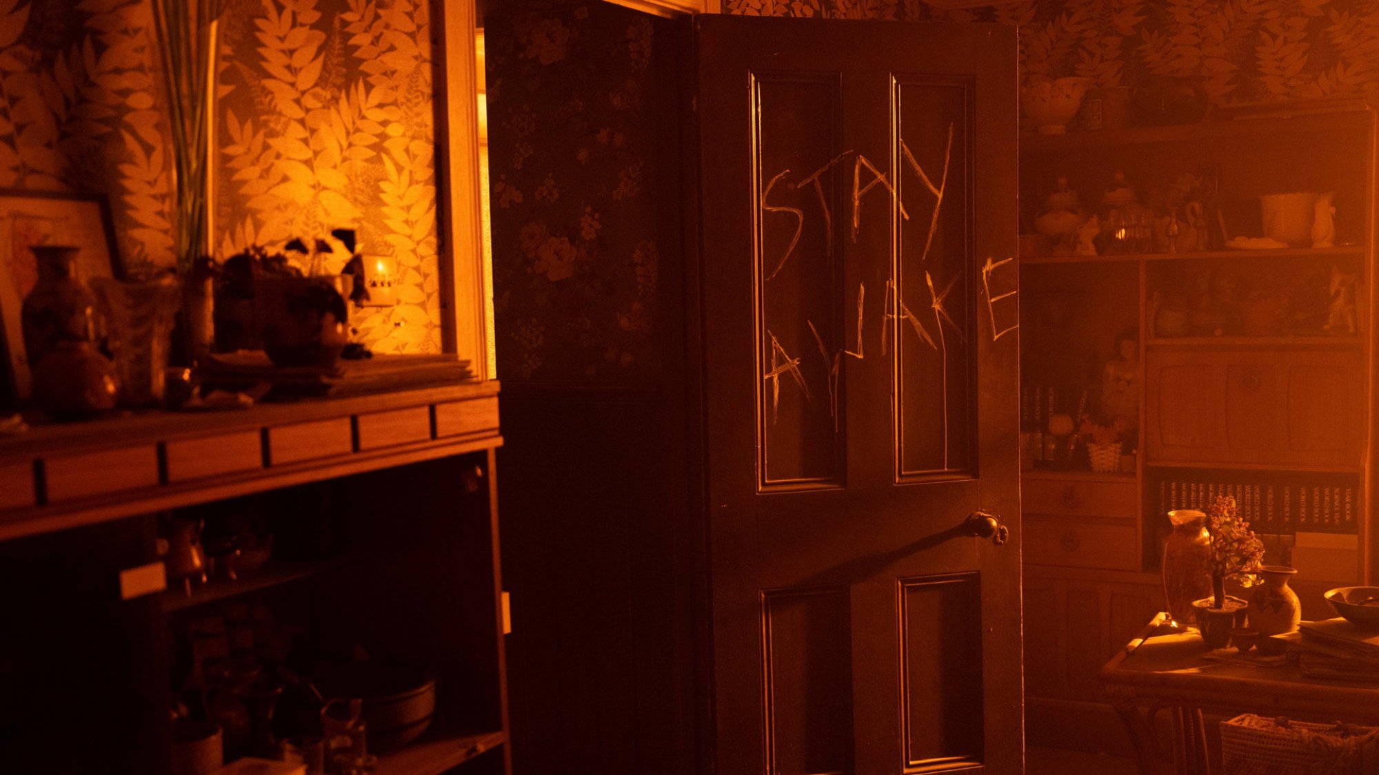 The words "stay awake" are carved into a door in the TV show "The Woman in the Wall"
