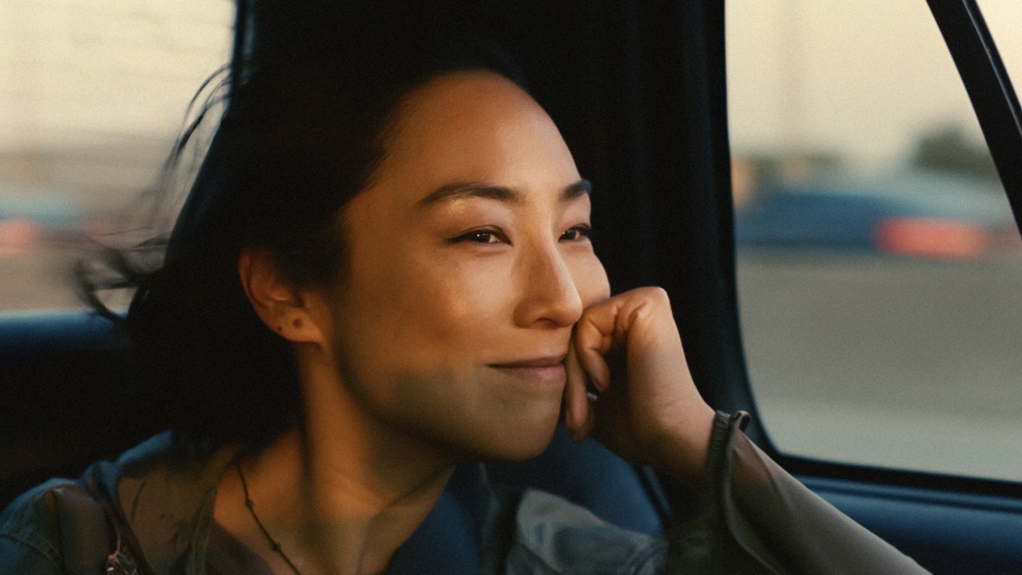 A woman smiling while riding in a car.