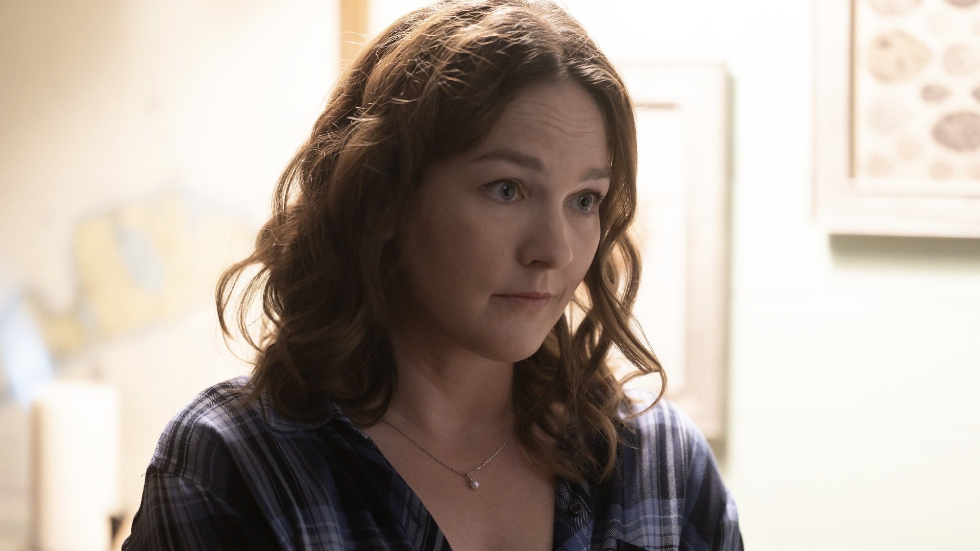 A woman in a blue flannel shirt.
