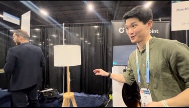 Man in green shirt points at an unlit lamp