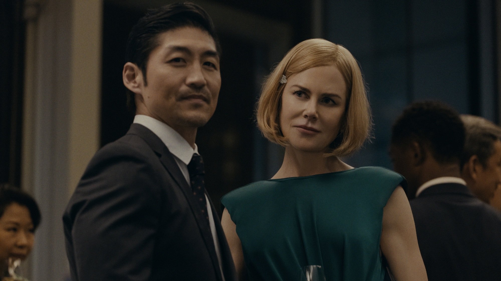 A man in a suit and a woman in a blue dress at a gala.