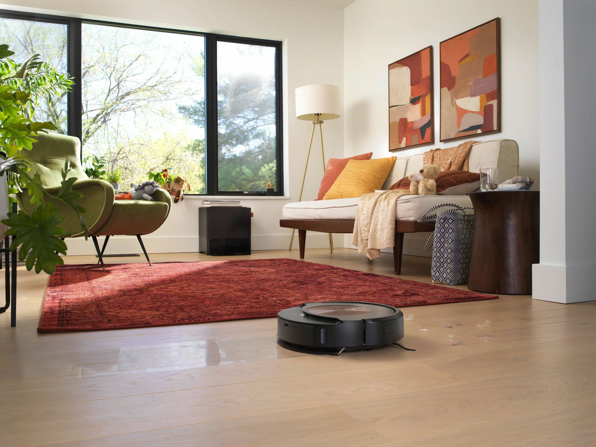Roomba mopping hardwood floor with living room furniture in background