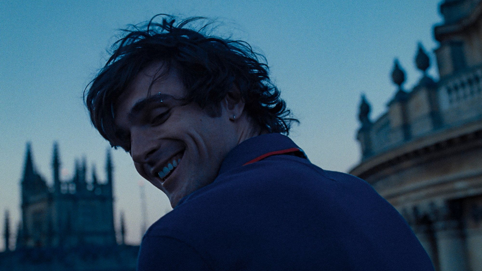 A young man turns around to smile at the camera at Oxford.