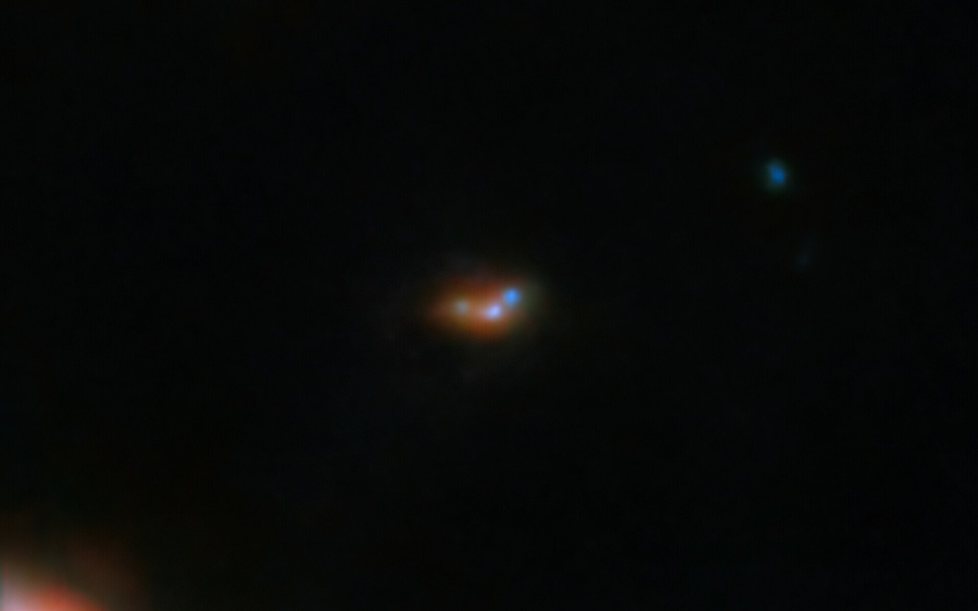 The extremely distant galaxy EGSY8p flanked by two smaller galaxies.
