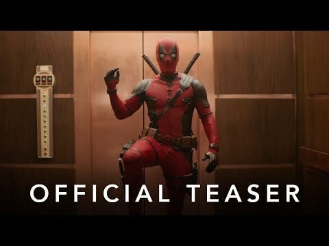 man in red and black suit stands in the elevator posing