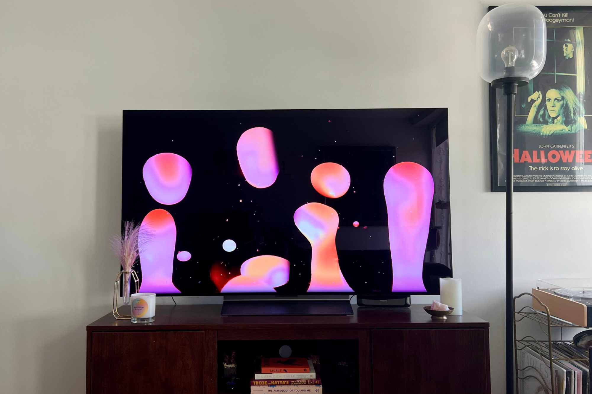 LG C3 TV with lava lamp screensaver sitting on TV stand with lamp in corner