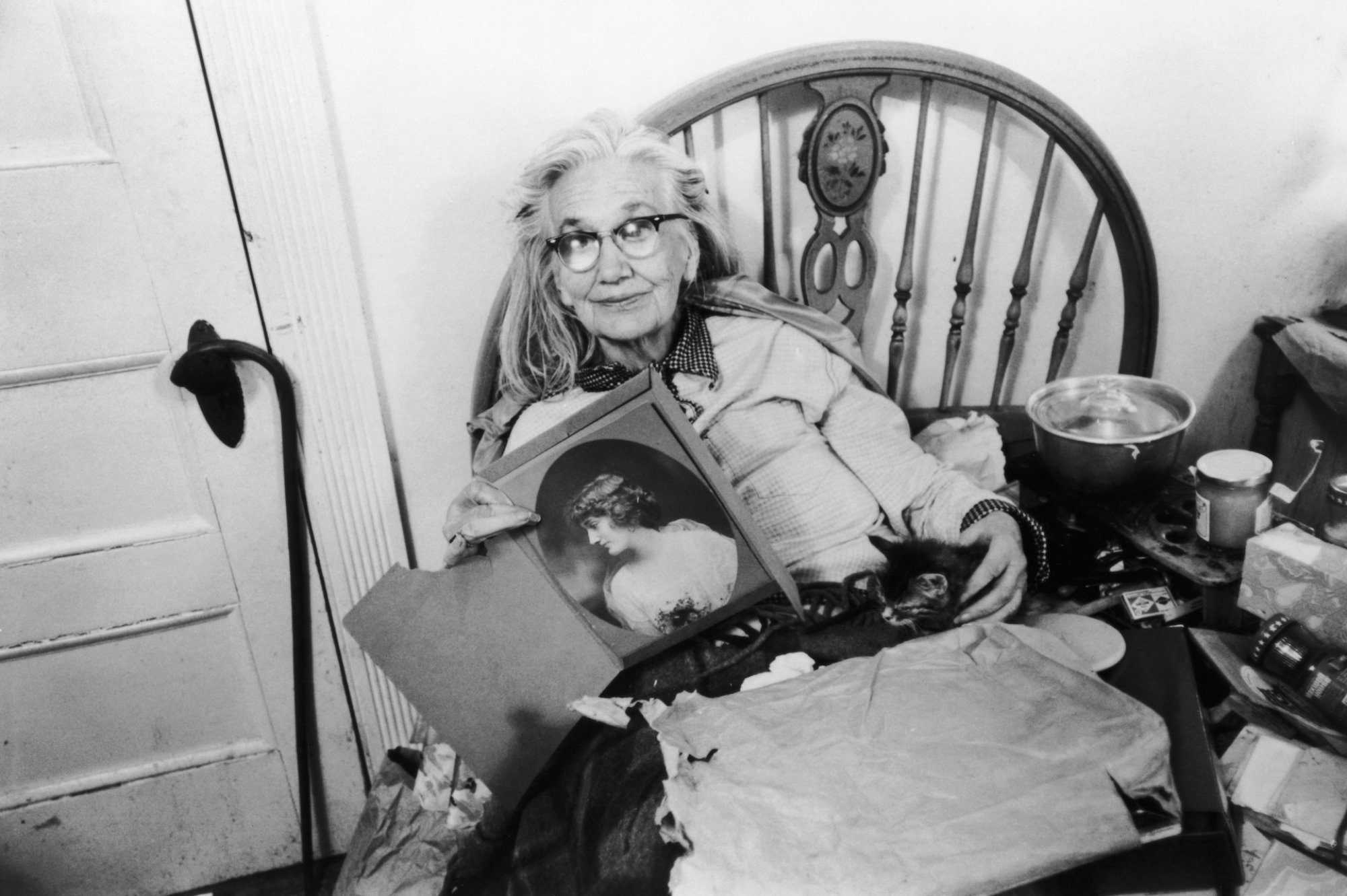 Edith Bouvier Beale, an elderly woman, lies in bed with an assortment of possessions.