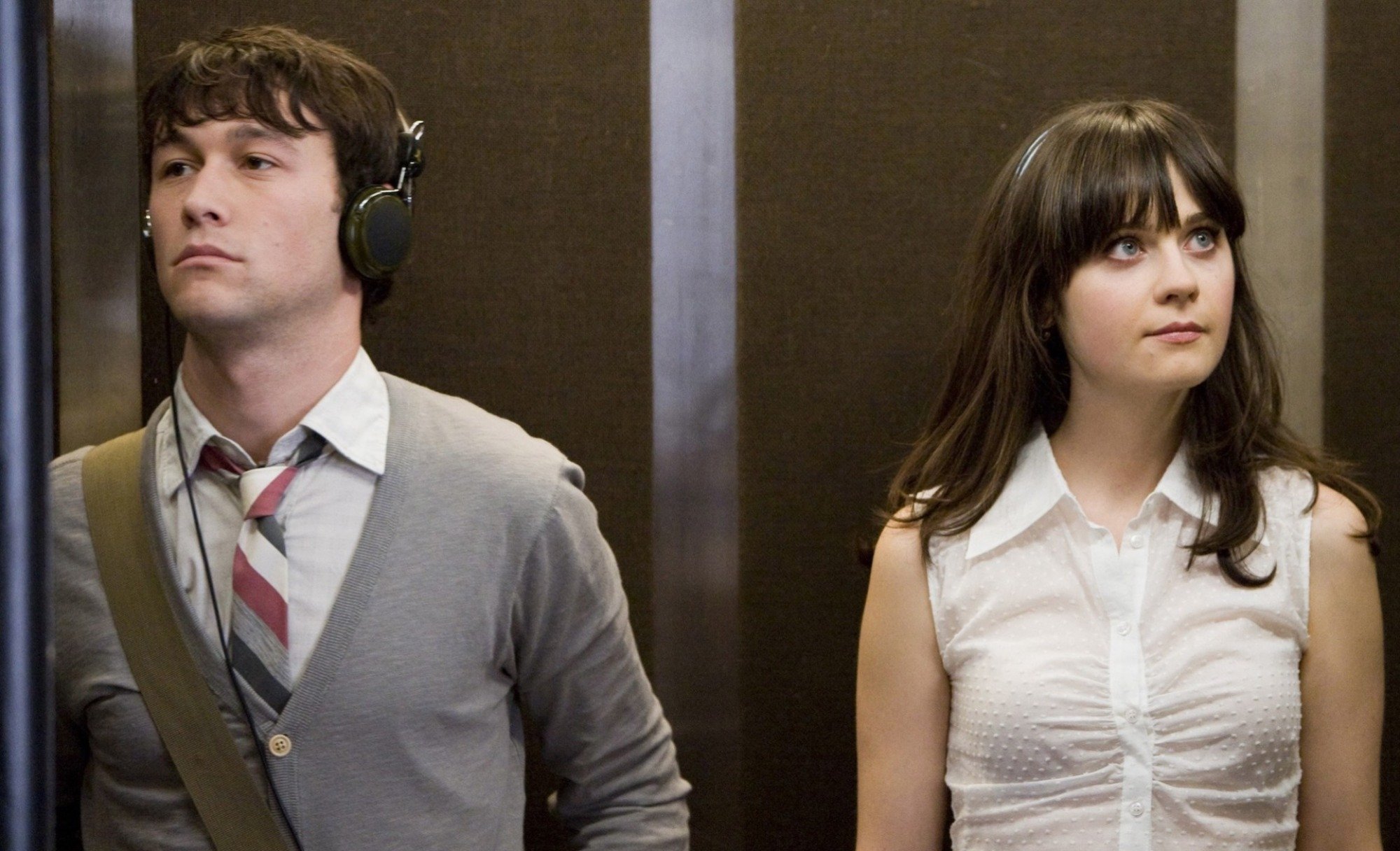 A man and woman standing in an elevator and looking away from each other; Joseph Gordon-Levitt and Zoeey Deschanel in "500 Days of Summer."