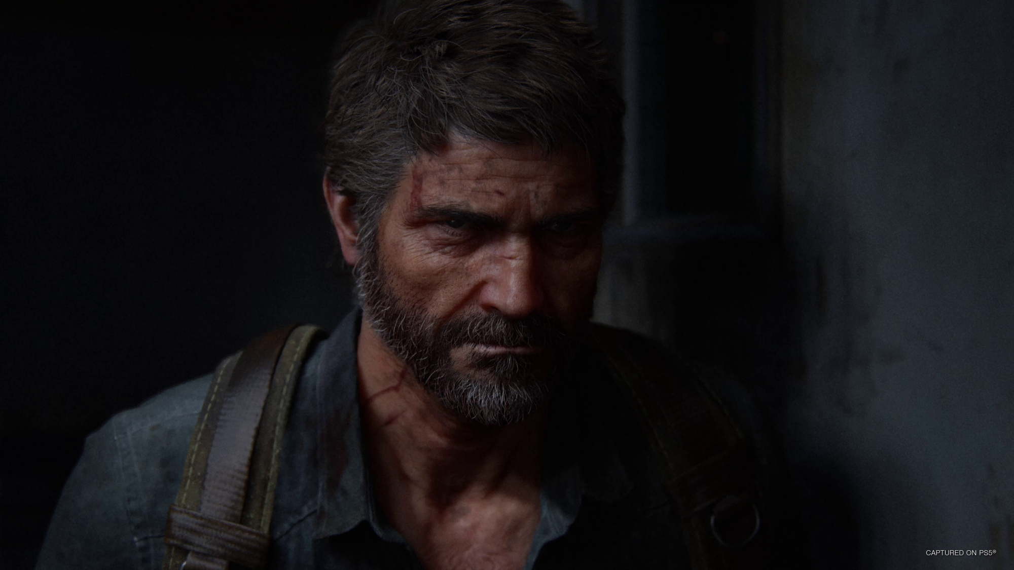 A brown hair white man is covered in shadow as he looks stenrly into the camera
