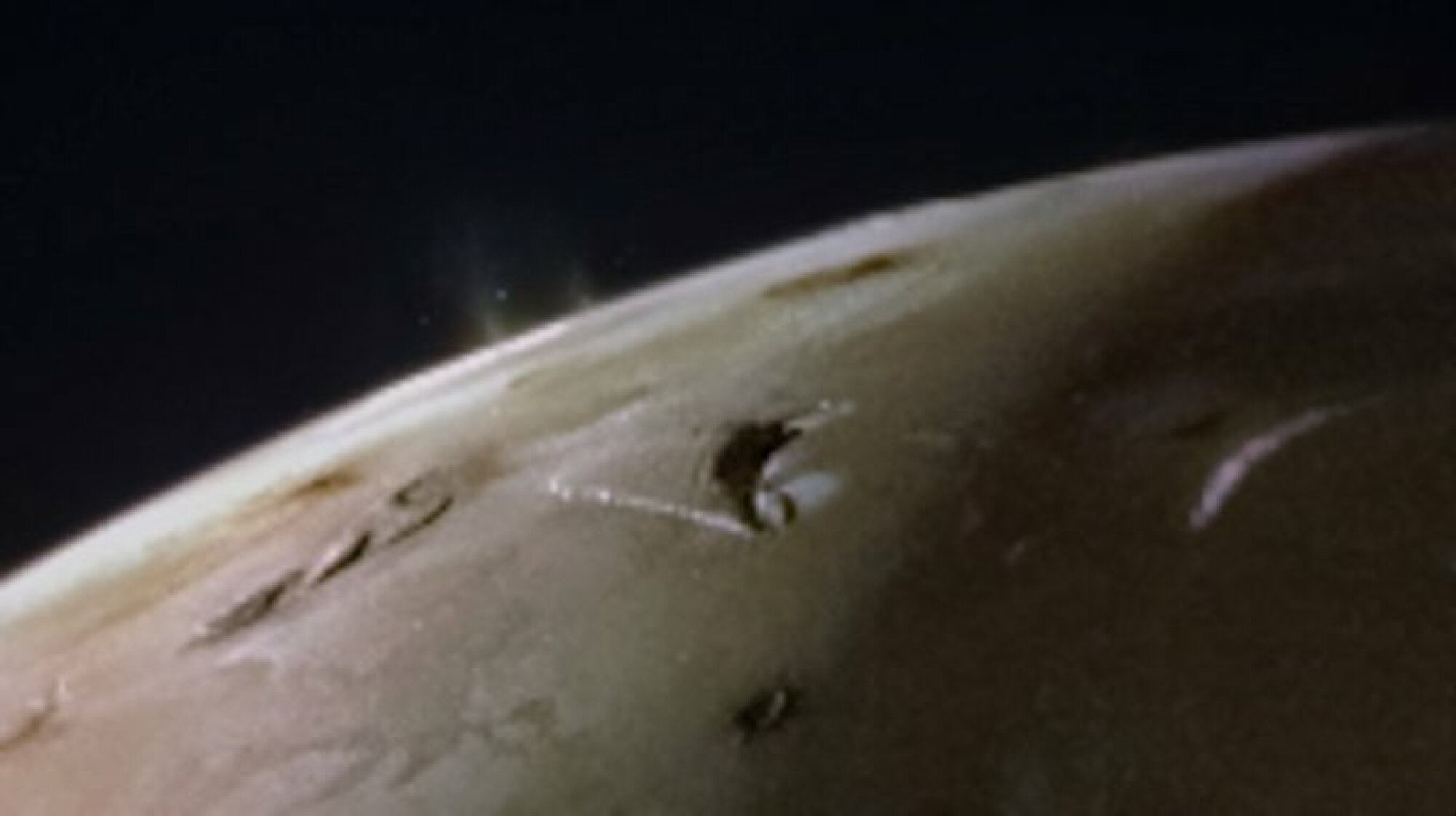 Two volcanic plumes rising from Io's surface.