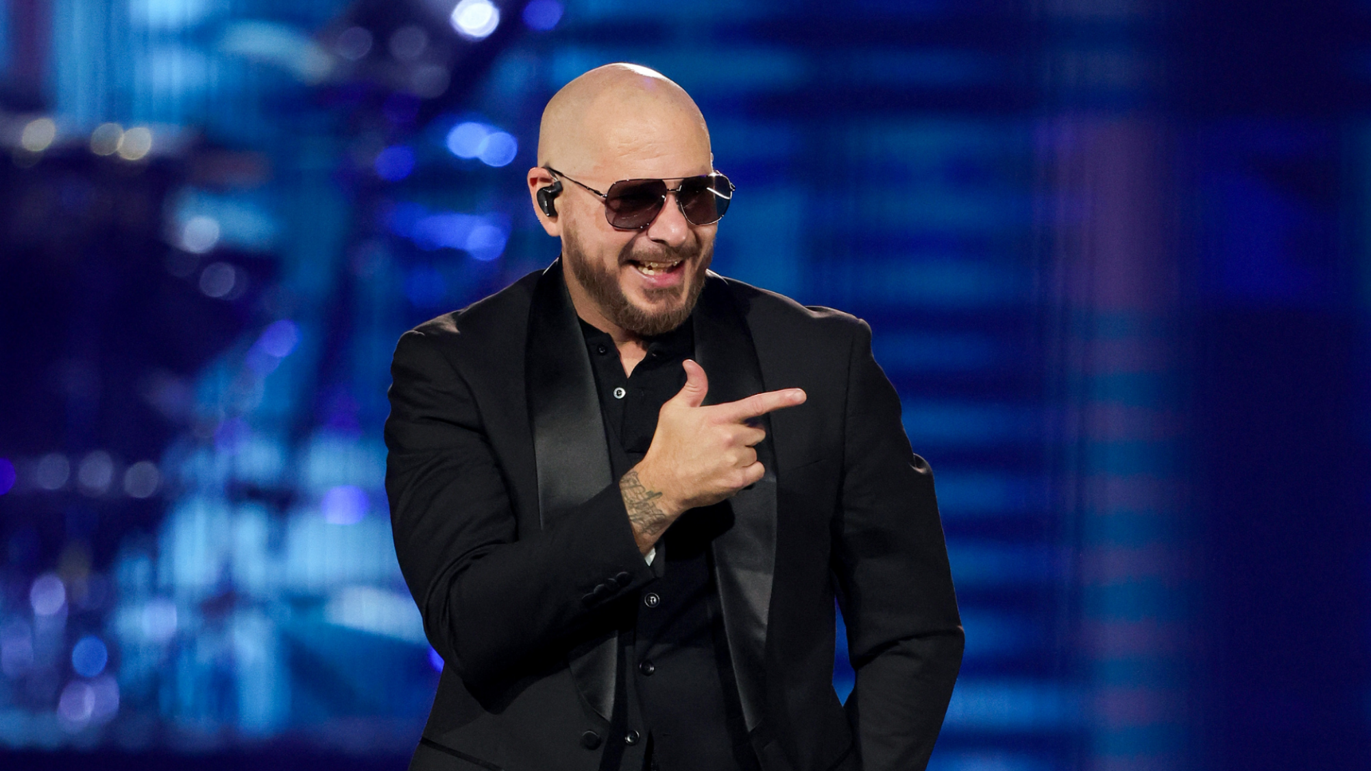 Pitbull (the singer) in black glasses and a black tux.