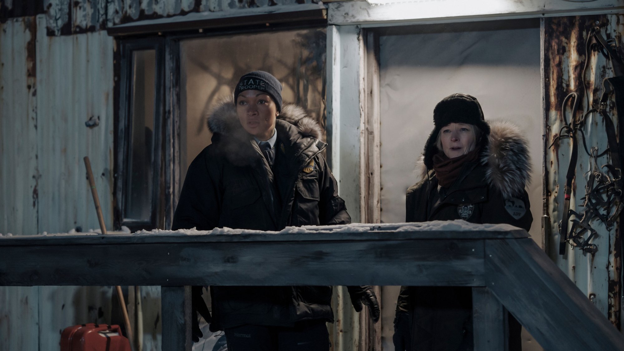 Police chief Liz Danvers (Jodie Foster) and state trooper Evangeline Siqiññaatchiaq Navarro (Kali Reis) stand outside a dilapidated house.