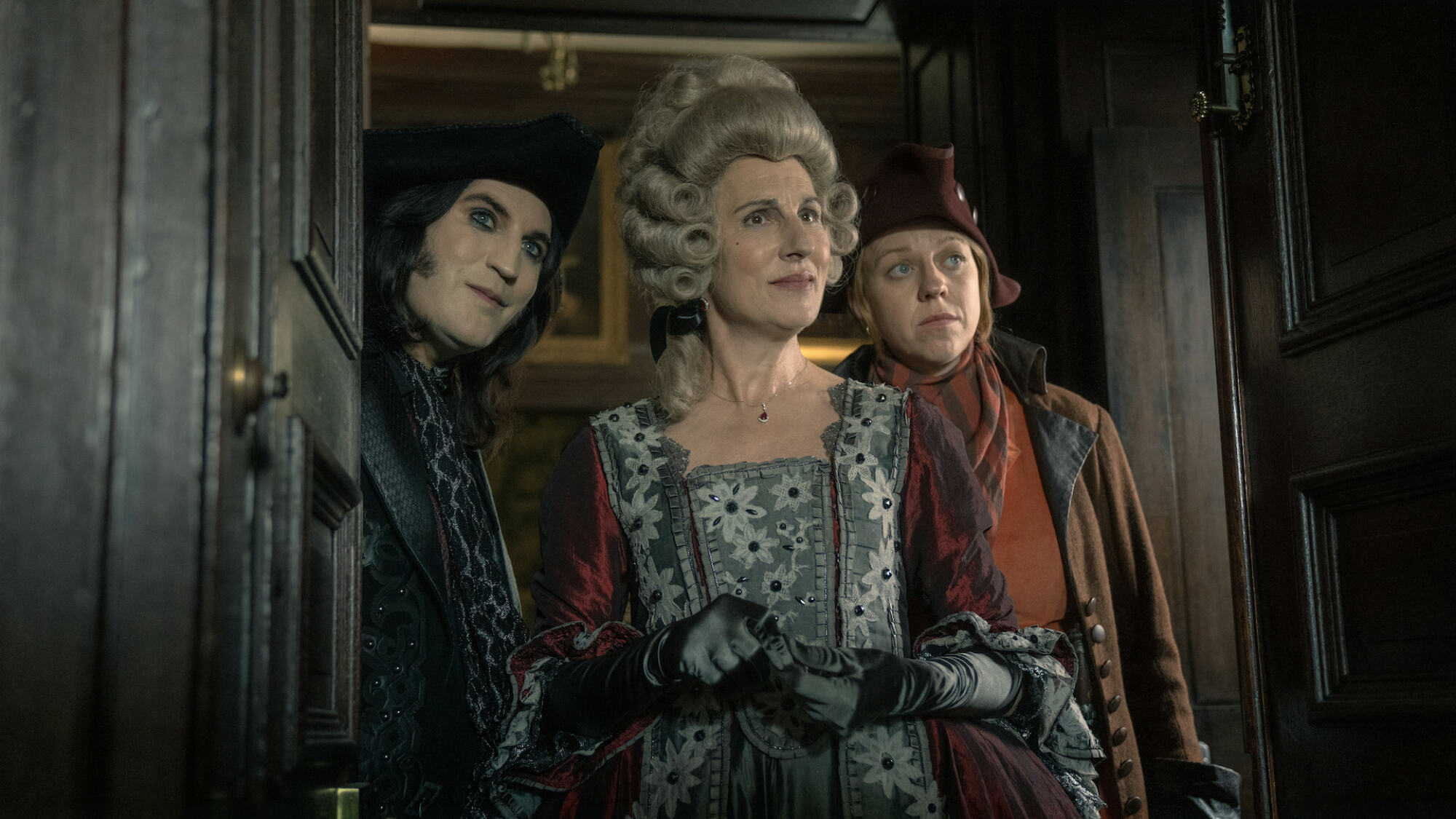 Two 18th century British highwaymen and an aristocratic woman stand in a doorway in "The Completely Made-Up Adventures of Dick Turpin"