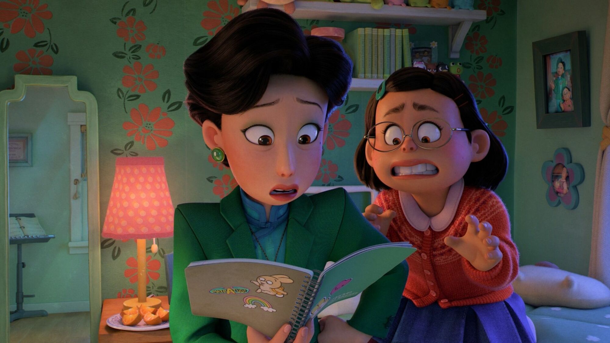 A mom looks at her young daughter's notebook; both look alarmed.