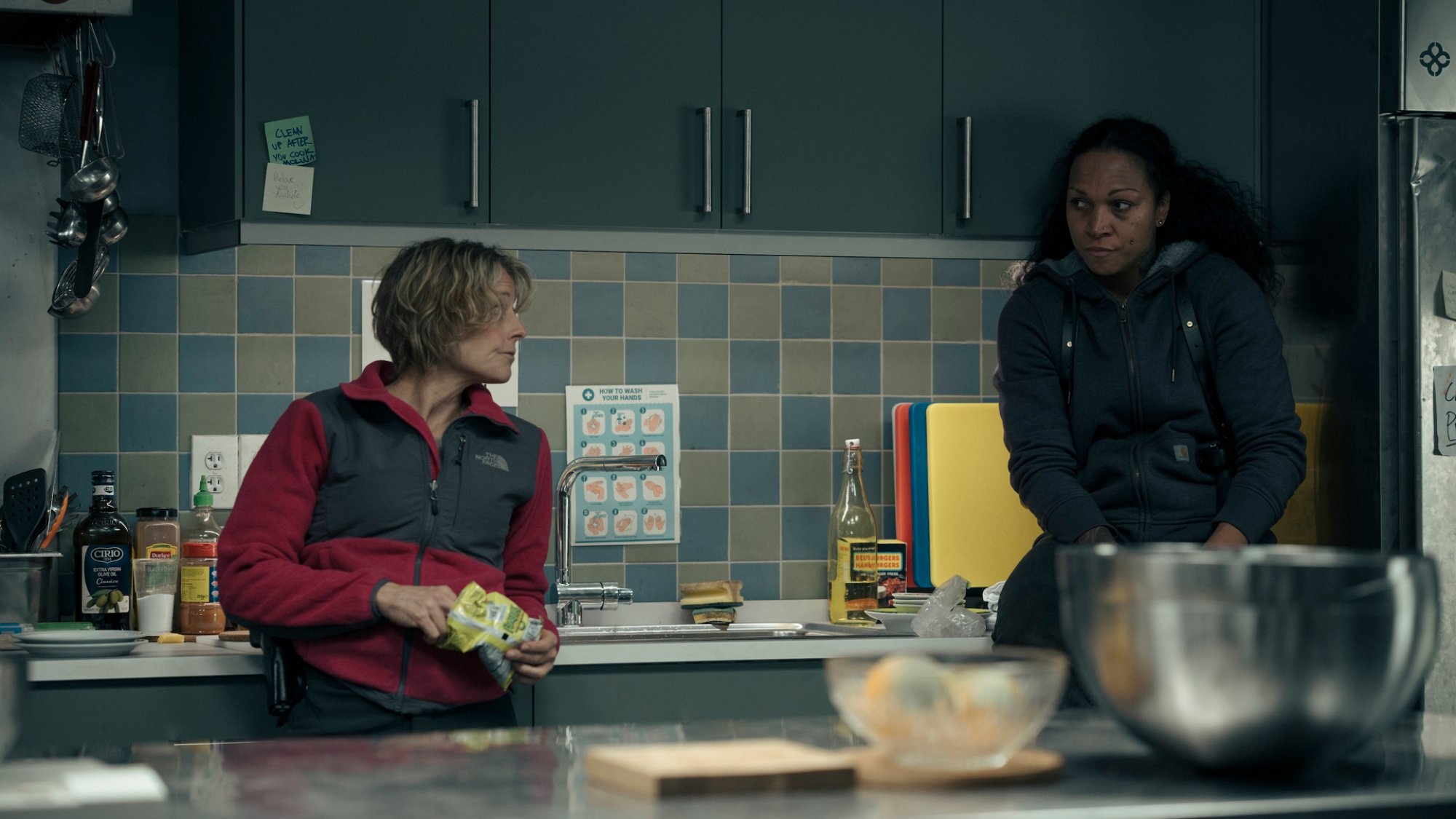 Jodie Foster and Kali Reis stand casually in a facility kitchen.