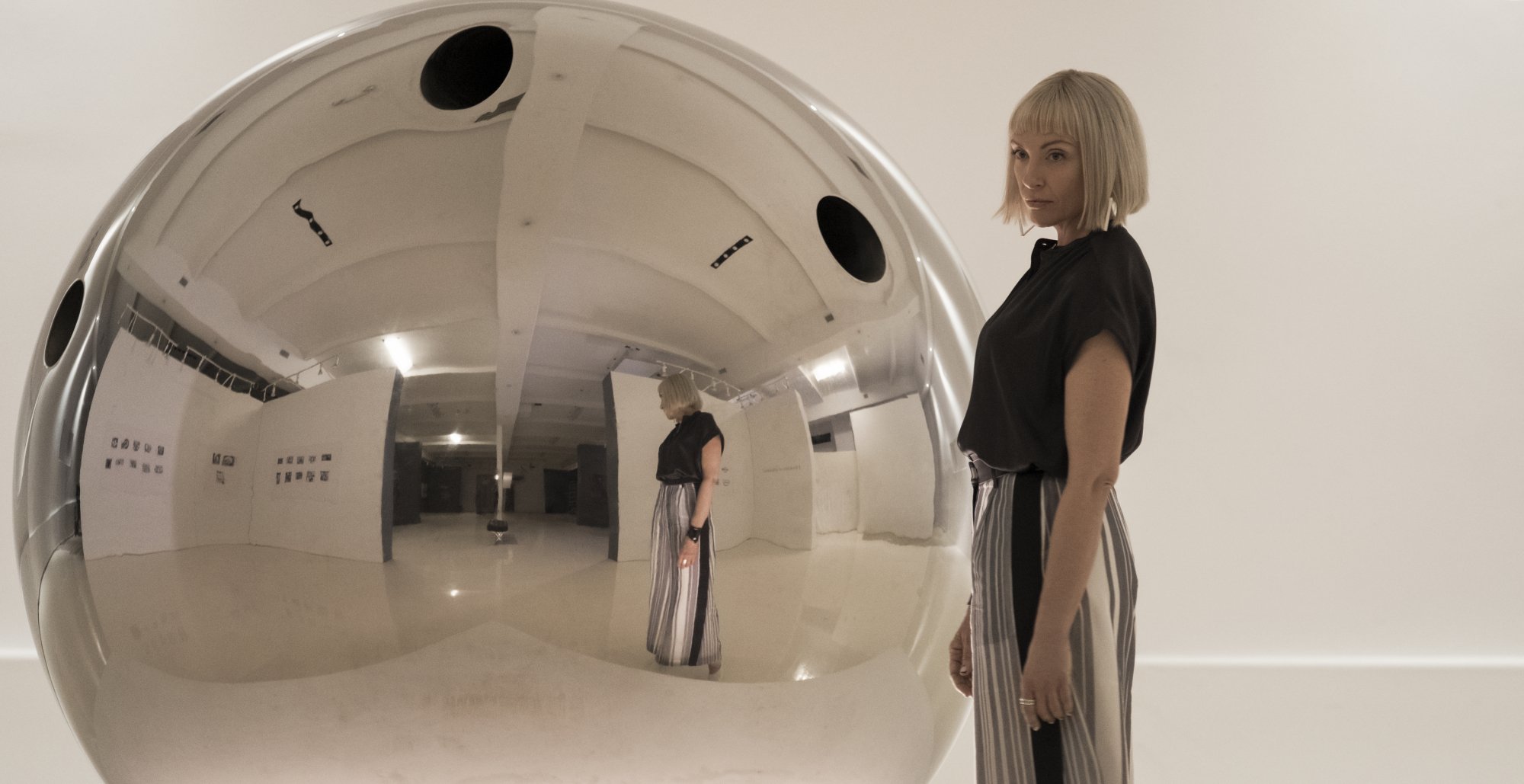 A woman stands in an art gallery.