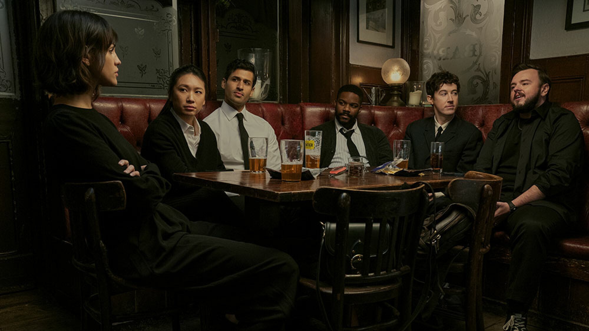 A group of people sit around a table at a pub.
