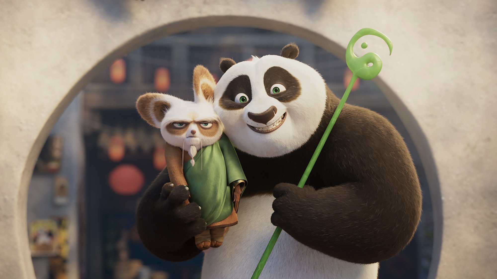 A smiling panda holds a scowling red panda.