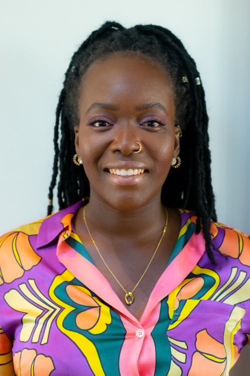 A headshot of Seyi Akiwowo, wearing a brightly coloured top.