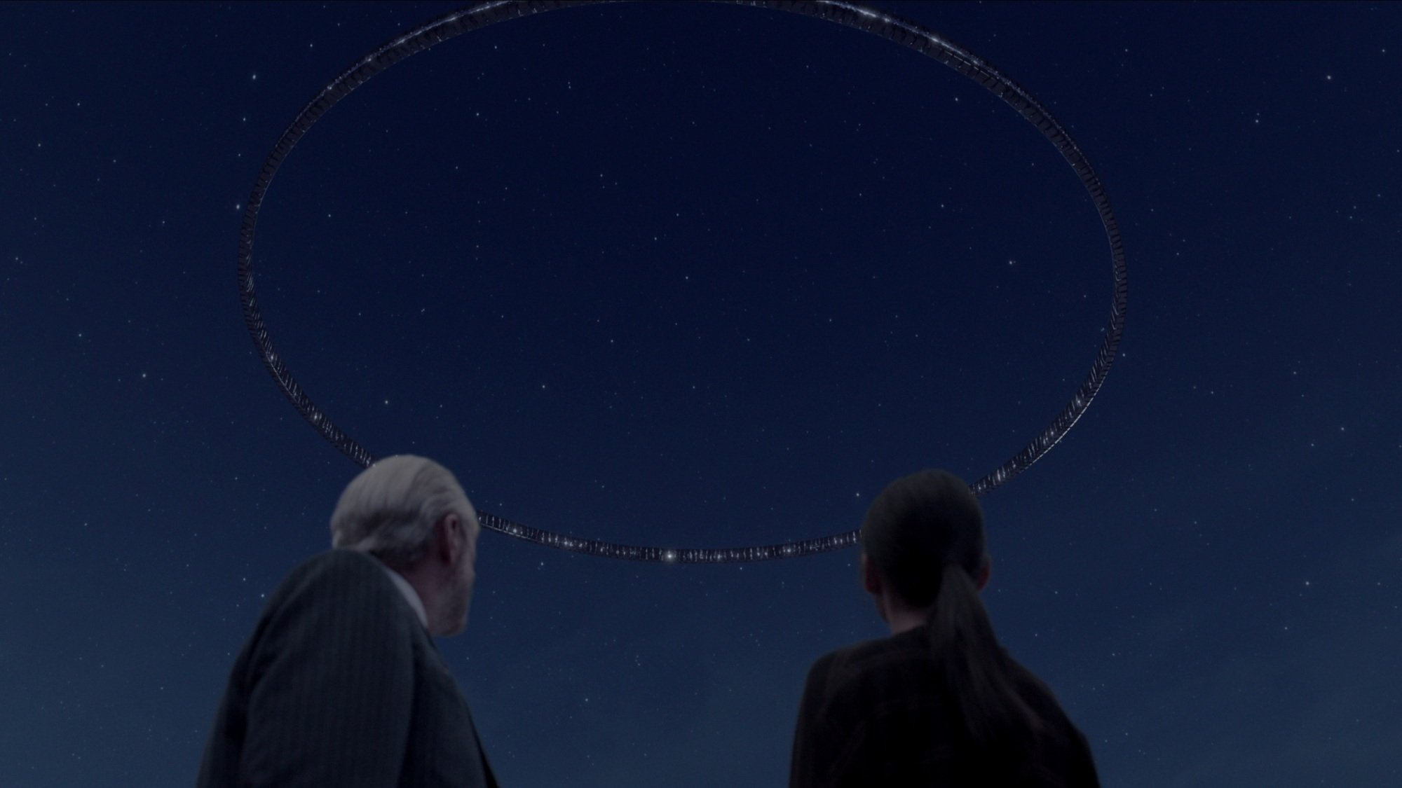 A man and woman look up at a massive alien circle in the sky.