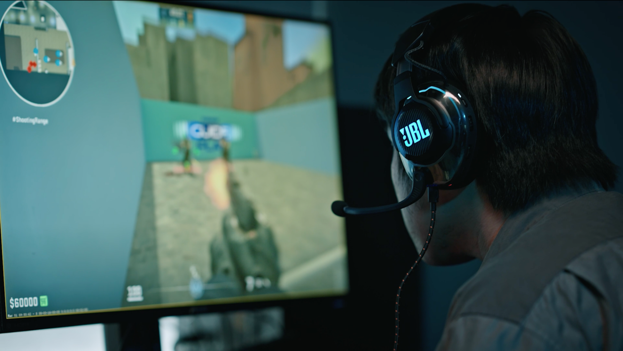 A gamer with JBL headphones plays a first person shooter.