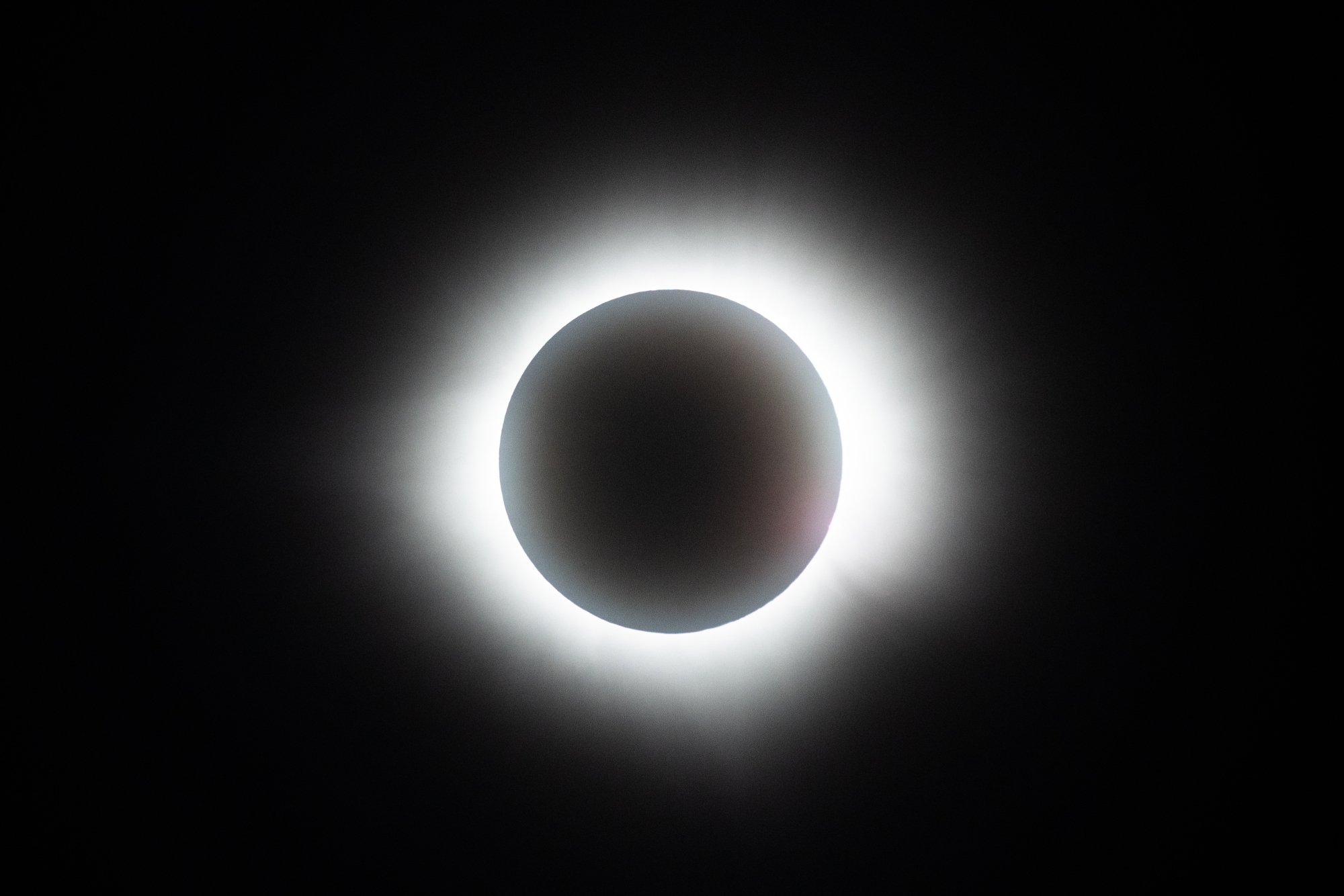 The sun fully disappears behind the moon during the solar eclipse on April 08, 2024 in Mazatlan, Mexico. The light behind the moon is bright and white.