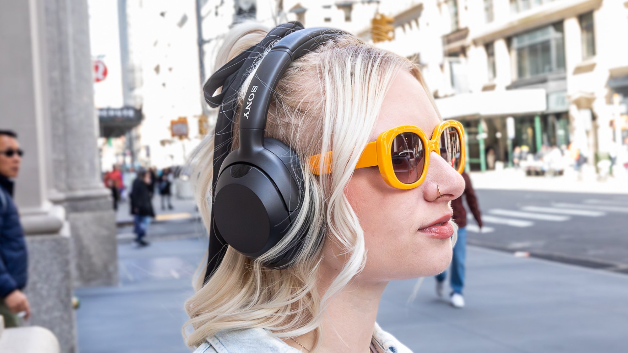 woman wearing over-ear headphones outside on NYC street