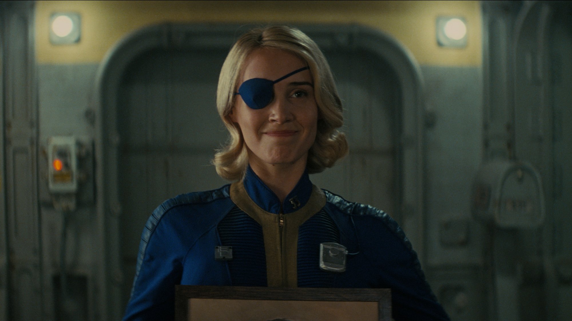Annabel O’Hagan wears a blue jumpsuit and an eyepatch as Stephanie Harper in "Fallout."