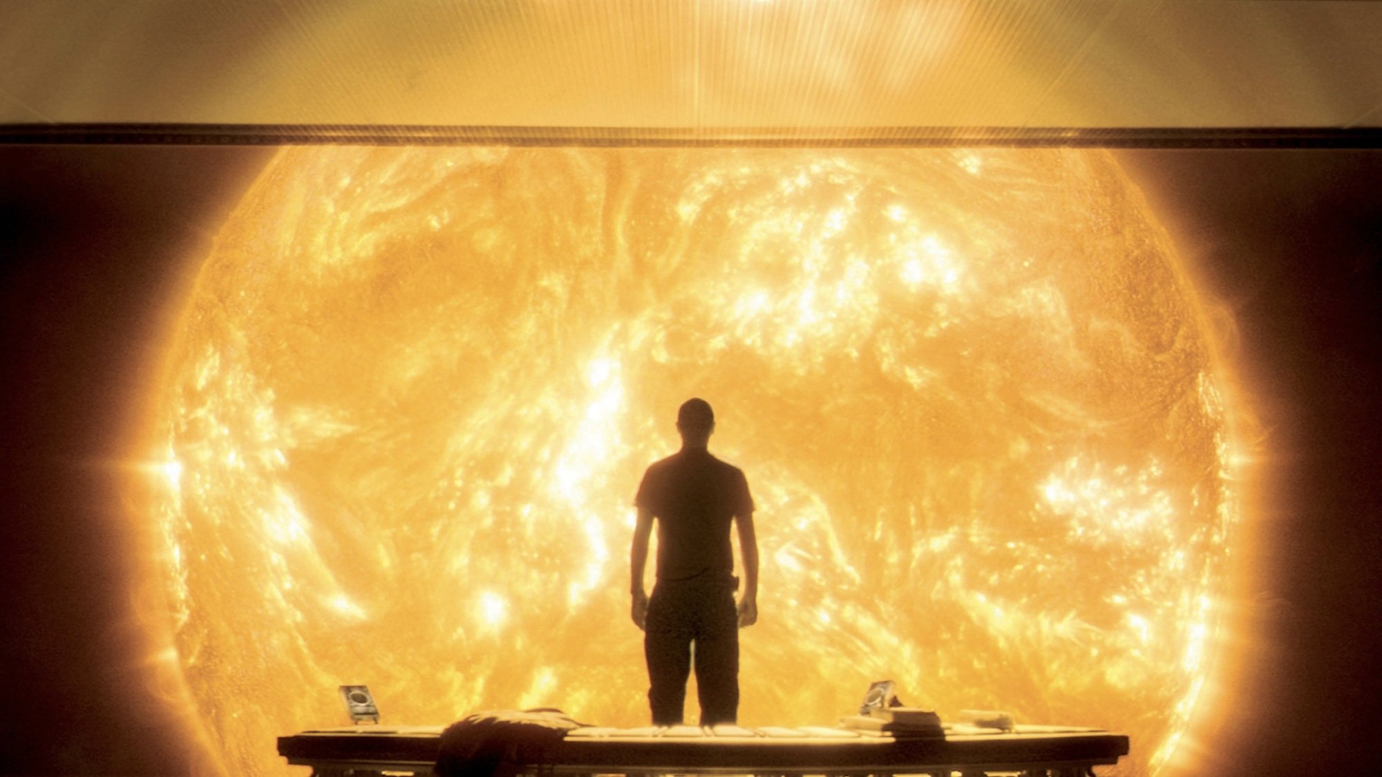 A man in a spaceship stares out at the sun.