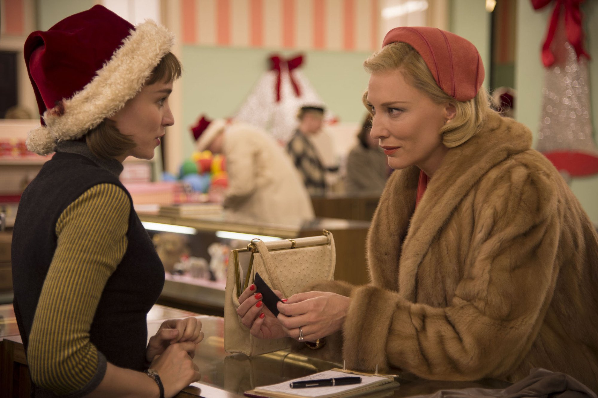 Two women look at each other across a sales counter.