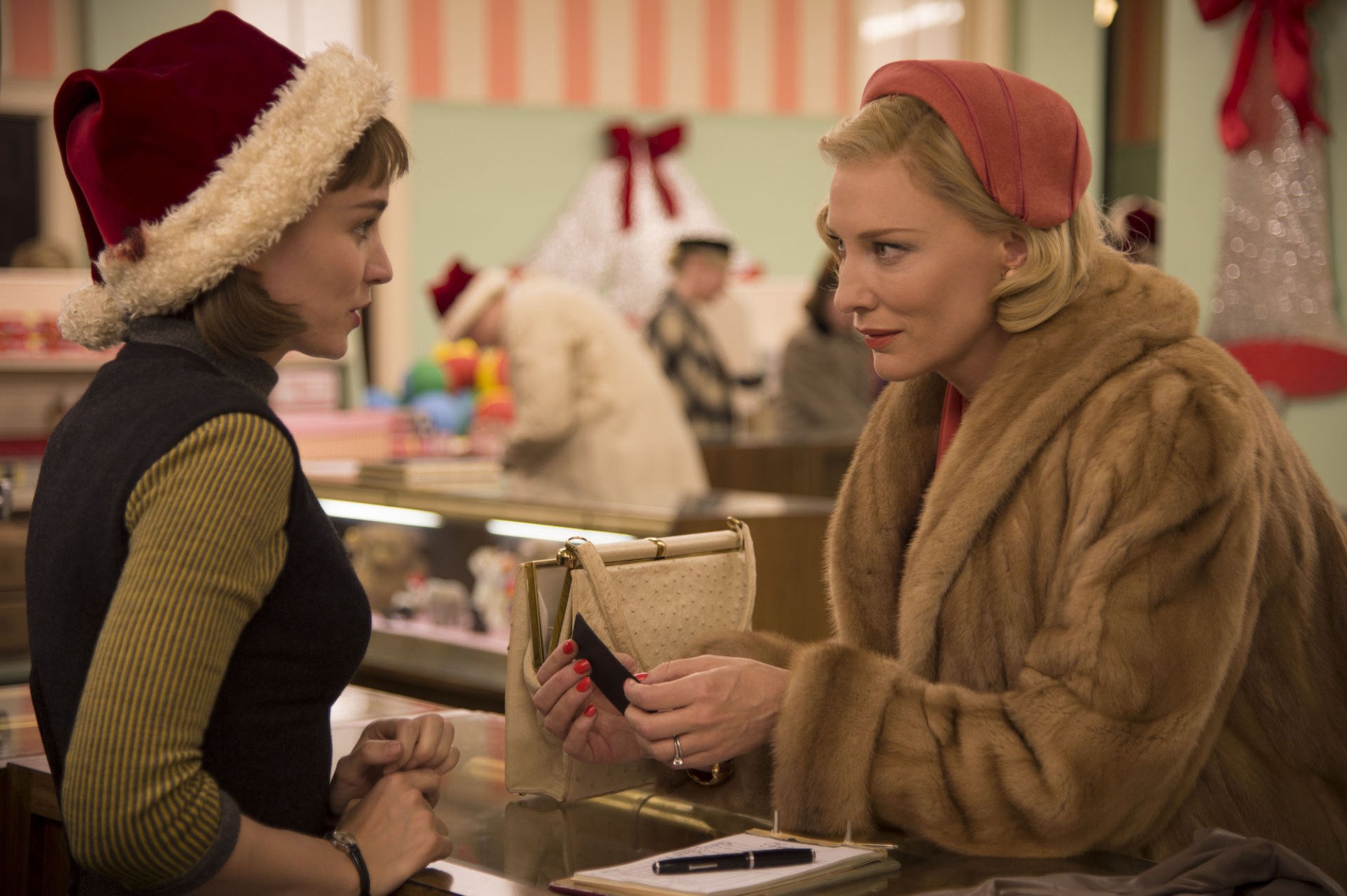 Two women look at each other across a sales counter. 